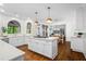 Bright, open kitchen with a center island, white cabinetry, stainless steel appliances, and hardwood floors at 605 Linkside Hollow, Alpharetta, GA 30005