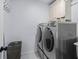 Modern laundry room with washer, dryer, and storage cabinets at 605 Linkside Hollow, Alpharetta, GA 30005