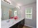 Bathroom featuring a double sink vanity, large mirror, and confetti decor at 325 Paces Dr, Lithia Springs, GA 30122