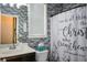 Stylish bathroom with modern vanity, brick accent wall, and elegant shower curtain, creating a spa-like retreat at 325 Paces Dr, Lithia Springs, GA 30122