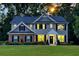 Inviting home at twilight with warm lighting, well-manicured lawn, and charming curb appeal at 325 Paces Dr, Lithia Springs, GA 30122