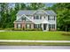 Classic two-story house with gray siding, brick details, and a well-kept lawn, perfect for Gathering living at 325 Paces Dr, Lithia Springs, GA 30122