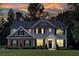 Beautiful home at dusk with illuminated windows, showcasing its welcoming ambiance and architectural details at 325 Paces Dr, Lithia Springs, GA 30122