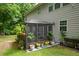 Cozy sunroom addition to the home's exterior featuring a screened-in enclosure and landscaping at 325 Paces Dr, Lithia Springs, GA 30122