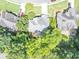 Aerial shot of a home's roof, driveway, and surrounding trees in a residential neighborhood at 4157 Berkeley Nw Lndg, Kennesaw, GA 30144