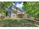 Green backyard featuring a wooden deck, mature trees, and patio area at 4157 Berkeley Nw Lndg, Kennesaw, GA 30144