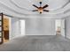 Bedroom with a trey ceiling, fan, barn door to the bathroom, doorway, and gray carpet at 4157 Berkeley Nw Lndg, Kennesaw, GA 30144