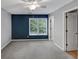 Bedroom with neutral walls, a blue accent wall, carpet flooring, and a window with natural light at 4157 Berkeley Nw Lndg, Kennesaw, GA 30144