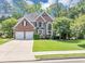Two-story brick home with a manicured lawn, two car garage, and a large front window at 4157 Berkeley Nw Lndg, Kennesaw, GA 30144