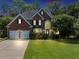 Two-story brick home with a manicured lawn, two car garage, and a large front window at 4157 Berkeley Nw Lndg, Kennesaw, GA 30144