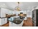 Open kitchen with stainless steel appliances, an island, modern lighting, and granite countertops at 4157 Berkeley Nw Lndg, Kennesaw, GA 30144