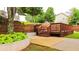 Backyard with mature trees, a wooden deck with railing, lush greenery, and a fenced yard, enhancing outdoor appeal at 4978 Arborview Pkwy, Acworth, GA 30101