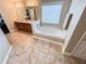Well-lit bathroom featuring a soaking tub, vanity with great counterspace, and tiled floors at 4978 Arborview Pkwy, Acworth, GA 30101
