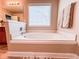 Bright bathroom featuring a soaking tub with a window and travertine-style floor tiles at 4978 Arborview Pkwy, Acworth, GA 30101