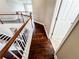 An elevated view of a hallway featuring wood floors, white banisters, stairs, and a glimpse of an adjacent room at 4978 Arborview Pkwy, Acworth, GA 30101