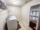 Bright laundry room with washer, dryer, and tile floor; overlooks upstairs railing at 4978 Arborview Pkwy, Acworth, GA 30101