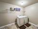 Bright laundry room with washer, dryer, tile floor, and storage shelf at 4978 Arborview Pkwy, Acworth, GA 30101