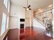 Spacious living room with tall windows, fireplace, ceiling fan, staircase, and hardwood floors at 4978 Arborview Pkwy, Acworth, GA 30101