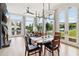Chic dining space with contemporary lighting, hardwood floors, and views of the patio and surrounding landscape through large windows at 100 5Th St, Fayetteville, GA 30214