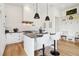 Well-lit kitchen with white cabinetry, center island, stylish fixtures, and open layout, perfect for cooking and entertaining at 100 5Th St, Fayetteville, GA 30214