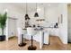 Modern kitchen with white cabinets, an island with seating, stainless steel appliances, and plenty of natural light at 100 5Th St, Fayetteville, GA 30214