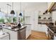 Bright kitchen featuring a center island, white cabinetry, hardwood floors, and an open design connected to the dining area at 100 5Th St, Fayetteville, GA 30214