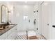 Bright main bathroom featuring dual sinks, gray countertops, white cabinetry, and a glass shower at 100 5Th St, Fayetteville, GA 30214
