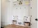 Organized mudroom with white built-in shelving, hooks, seating bench and decorative baskets at 100 5Th St, Fayetteville, GA 30214
