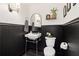 Stylish powder room featuring black wainscoting, pedestal sink, and classic fixtures at 100 5Th St, Fayetteville, GA 30214