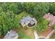 Aerial view of a beautifully landscaped home nestled among mature trees at 1335 Joy Ct, Suwanee, GA 30024