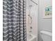 Neutral-toned bathroom featuring a shower with a gray wave-patterned shower curtain and white subway tile at 1335 Joy Ct, Suwanee, GA 30024