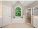 Bright bathroom features a soaking tub beneath an arched window and a separate glass-enclosed shower at 1335 Joy Ct, Suwanee, GA 30024