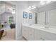 Bright bathroom vanity with double sinks next to a bedroom with blue accents and a ceiling fan at 1335 Joy Ct, Suwanee, GA 30024