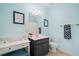 Light blue bathroom featuring a dark vanity, toilet, and decoratively framed ABC art at 1335 Joy Ct, Suwanee, GA 30024