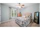 Cozy bedroom with a ceiling fan, patterned bedding, and plenty of natural light at 1335 Joy Ct, Suwanee, GA 30024