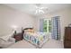 Comfortable bedroom with a dinosaur-themed bedspread, a bedside table, and a window with checked curtains at 1335 Joy Ct, Suwanee, GA 30024