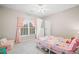 Cozy bedroom with pink accents featuring a twin bed, a window with light pink curtains, and a small armchair at 1335 Joy Ct, Suwanee, GA 30024