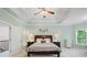 Elegant primary bedroom boasts tray ceilings, a ceiling fan, and is naturally well-lit at 1335 Joy Ct, Suwanee, GA 30024