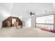 Large bonus room with built in shelving, ceiling fan, and carpeted floors at 1732 Winding Woods Ln, Jonesboro, GA 30236