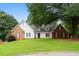 Charming two-story home with a well-manicured front yard, brick accents, and mature trees at 1732 Winding Woods Ln, Jonesboro, GA 30236