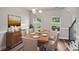 Sunlit dining room featuring hardwood floors, modern chandelier, and a dining table set for a formal meal at 176 Windy Cir, Mcdonough, GA 30253