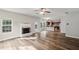 Open-concept living area with fireplace, hardwood floors, and seamless flow into a modern kitchen at 176 Windy Cir, Mcdonough, GA 30253