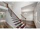 Elegant staircase with wood and iron railings, leading to an open floor plan with hardwood floors and modern lighting at 176 Windy Cir, Mcdonough, GA 30253