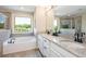 Bathroom featuring a large tub, glass enclosed shower, and dual sink granite vanity at 2039 West Hampton Dr, Canton, GA 30115