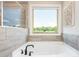Bathroom showcasing a large bathtub with a window view and stylish tile work at 2039 West Hampton Dr, Canton, GA 30115