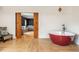 Luxurious bathroom featuring a freestanding red bathtub and dark wood sliding door at 2039 West Hampton Dr, Canton, GA 30115
