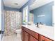 A bathroom with cherry wood cabinets, white countertops, a shower, and plenty of natural light at 2039 West Hampton Dr, Canton, GA 30115