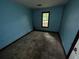 A bedroom with blue walls, dirty floors, and a window offering natural light at 2612 Ramblewood Ct, Acworth, GA 30102