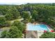 Aerial view of neighborhood pool with people swimming, pool furniture, and surrounding trees at 1170 Spring Oak Way, Cumming, GA 30041