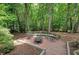Beautiful backyard patio with fire pit and seating surrounded by lush trees at 1170 Spring Oak Way, Cumming, GA 30041